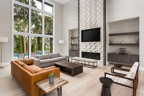 Professionally designed living room with a Contemporary decor style, a large window, light colored wood floors, with a fireplace and a television as the centerpieces of the room