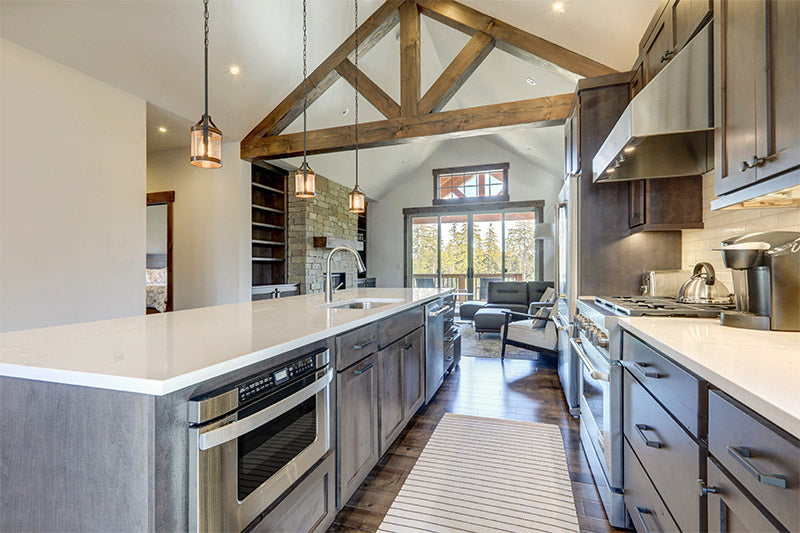 An interior photo of a professionally designed Modern Mountain decor style kitchen with a large window and exposed wood beams