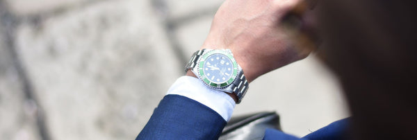 guy in suit looking at rolex watch