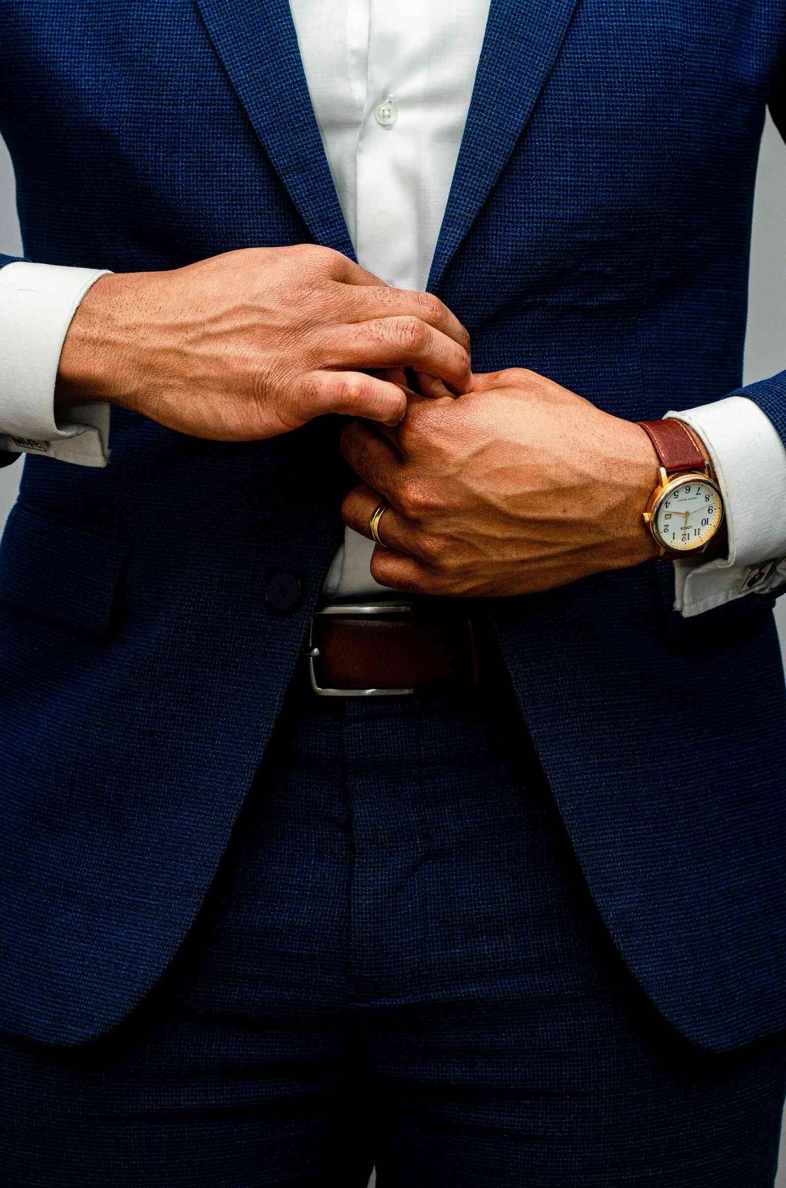 man buttoning up blazer with nice watch business casual outfit