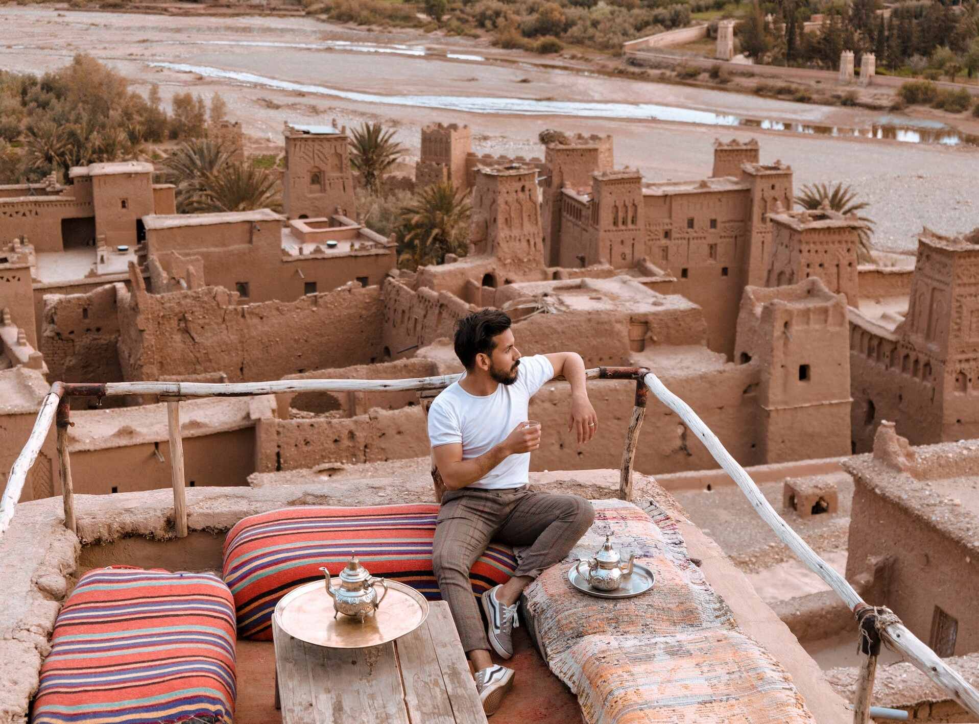 man sitting on vacation in nice outfit overlooking desert city
