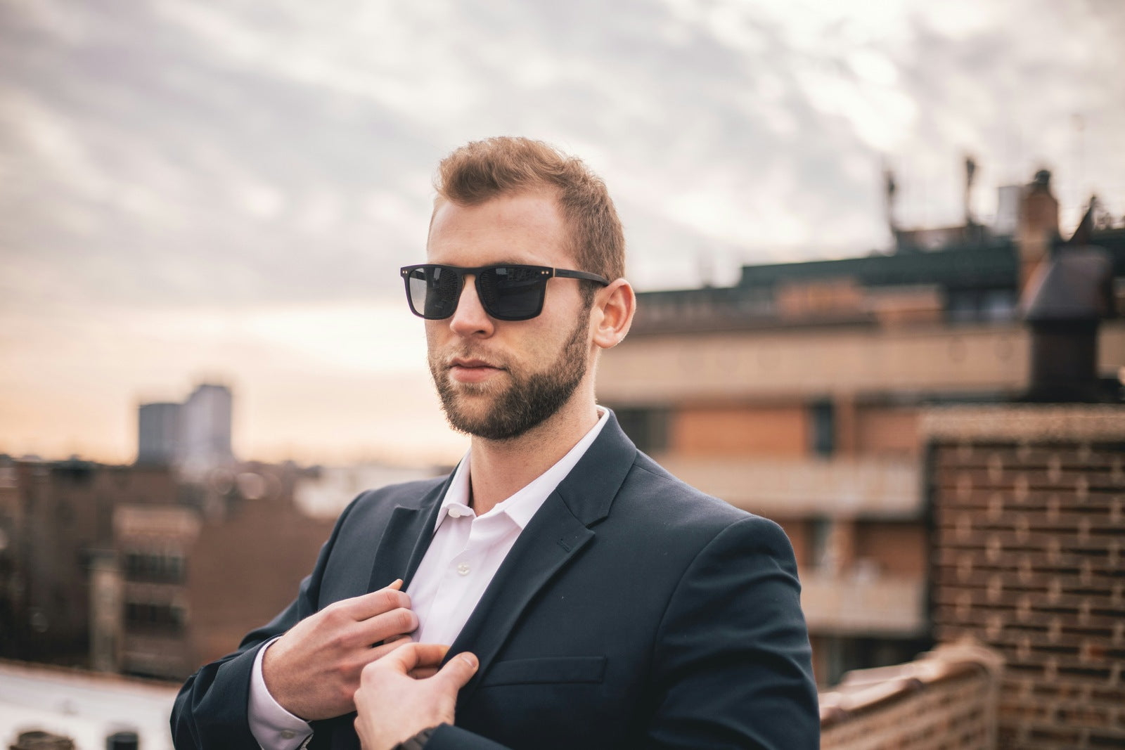 man with sunglasses on in blazer and dress shirt business casual outfit