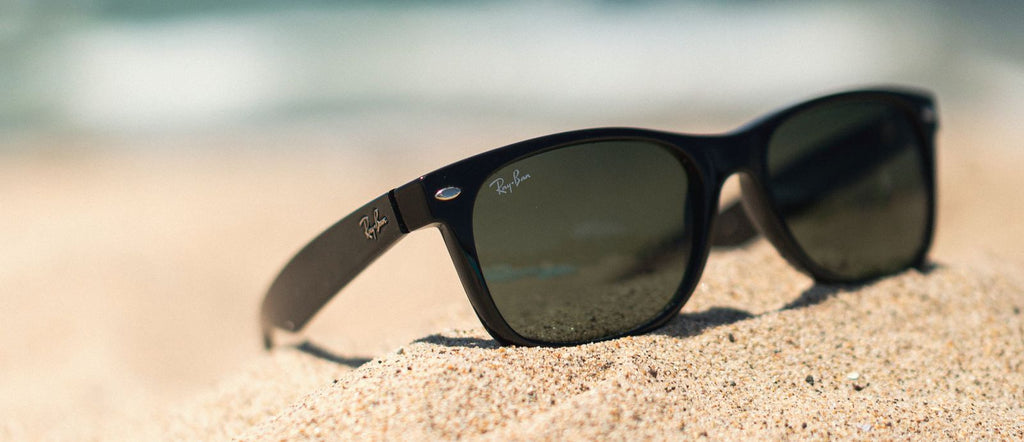 ray ban sunglasses on the beach in sand for travel