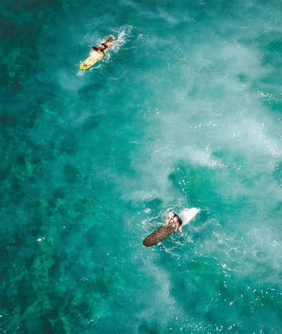 Surfers paddling out the back 
