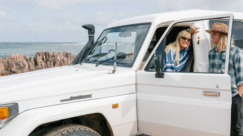 A couple smiling with Smelly Balls Reusable air freshener in a Toyota Land Cruiser