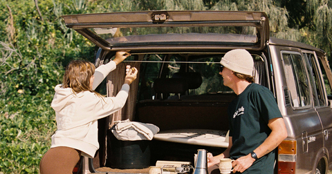 Two people sitting in the back of their car