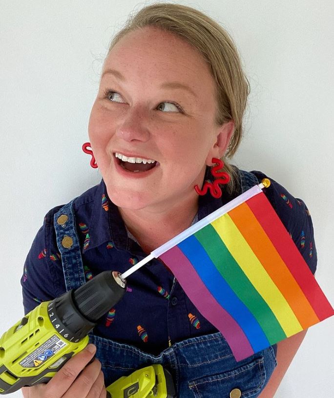 Terry Moore photo holding a drill with LGBTQ+ flag