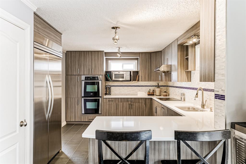 kitchen interior design white quartz countertop with laminate cabinets stainless steel appliances fridge and plumbing sink and faucet