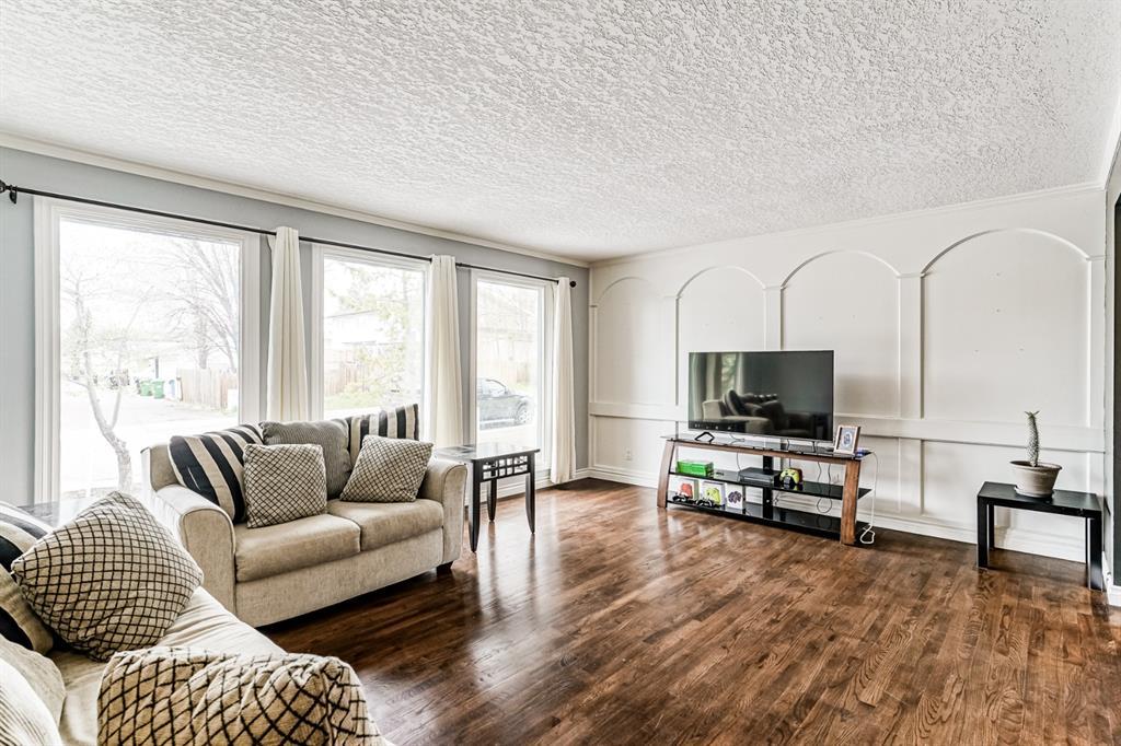 1970 Calgary home listing with huge fixed windows wood floor planks white painted wall and ceilings