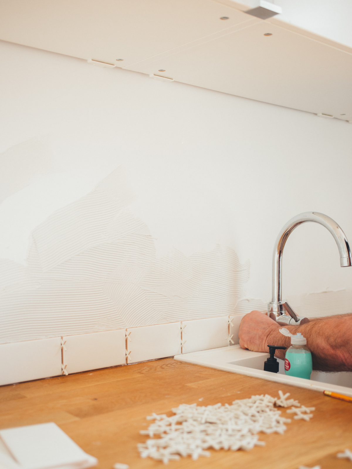 person fixing the faucet and kitchen sink