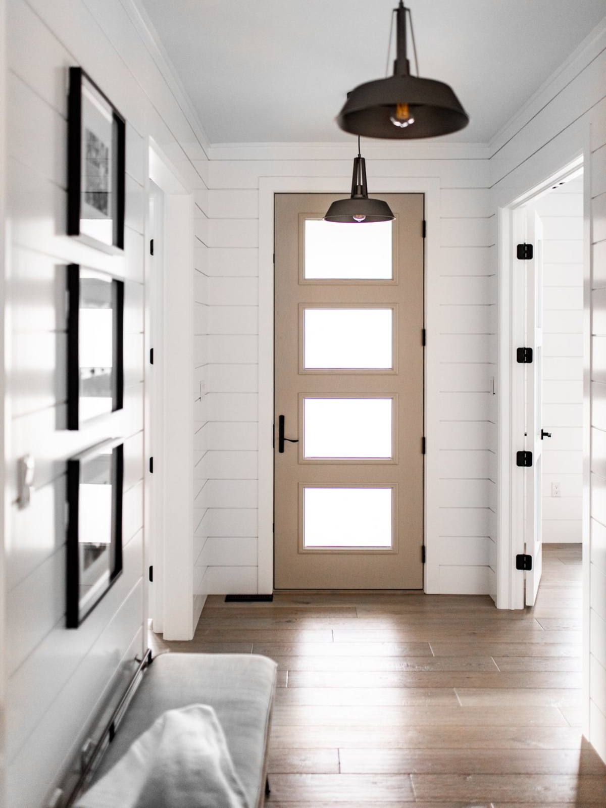 foyer with wooden floor, door and wall gallery