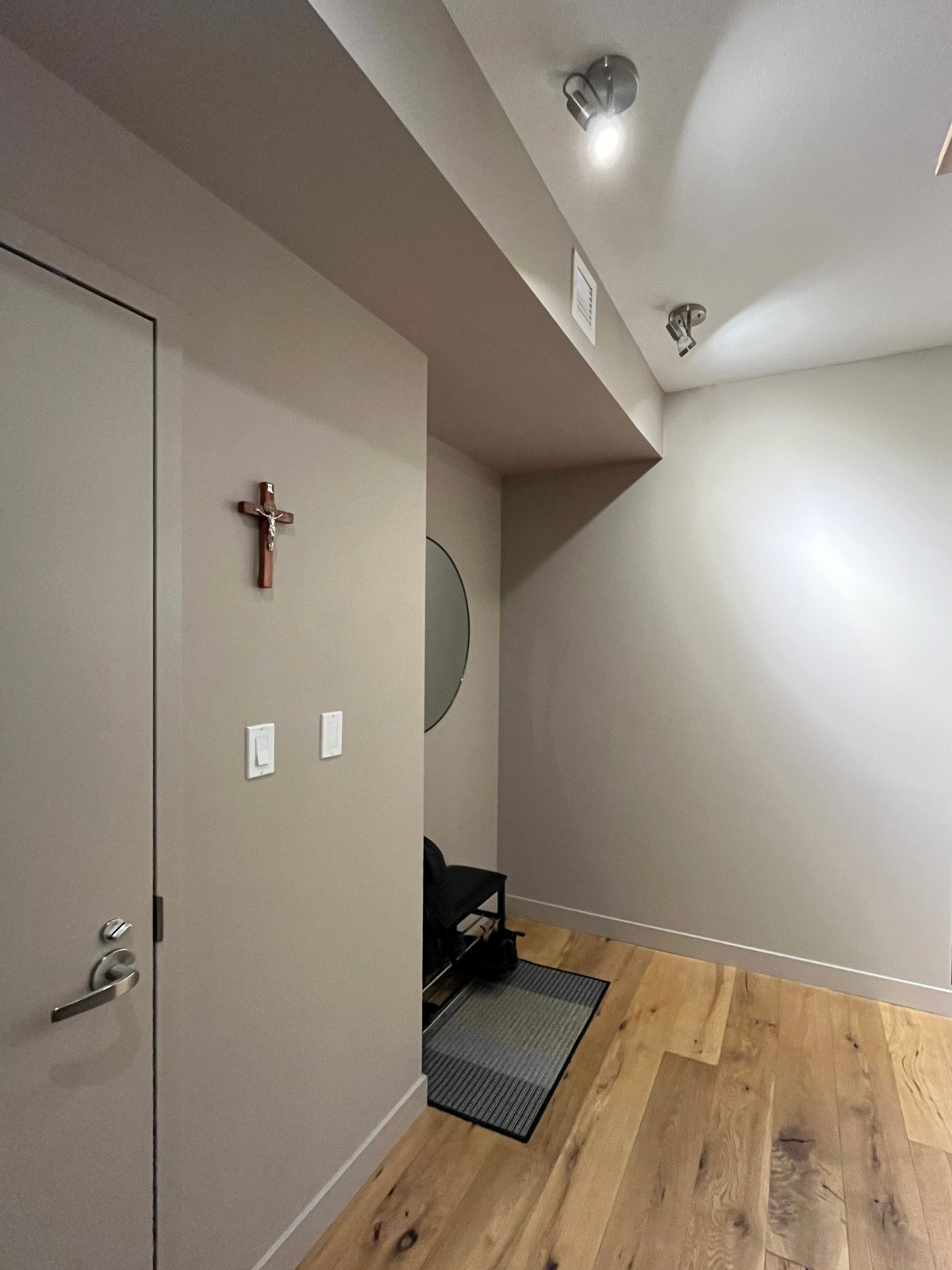 existing foyer space with grey cabinets, white ceiling, painted walls and engineered wooden floors