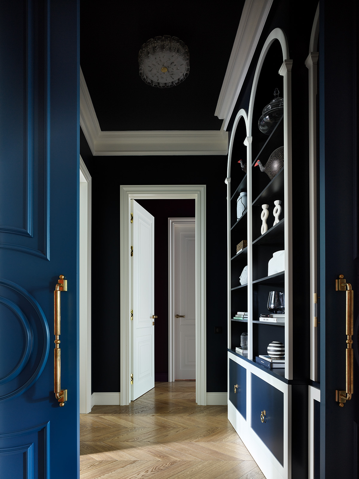 hallway with wooden floor, shelves and walls and doors painted in blue paint