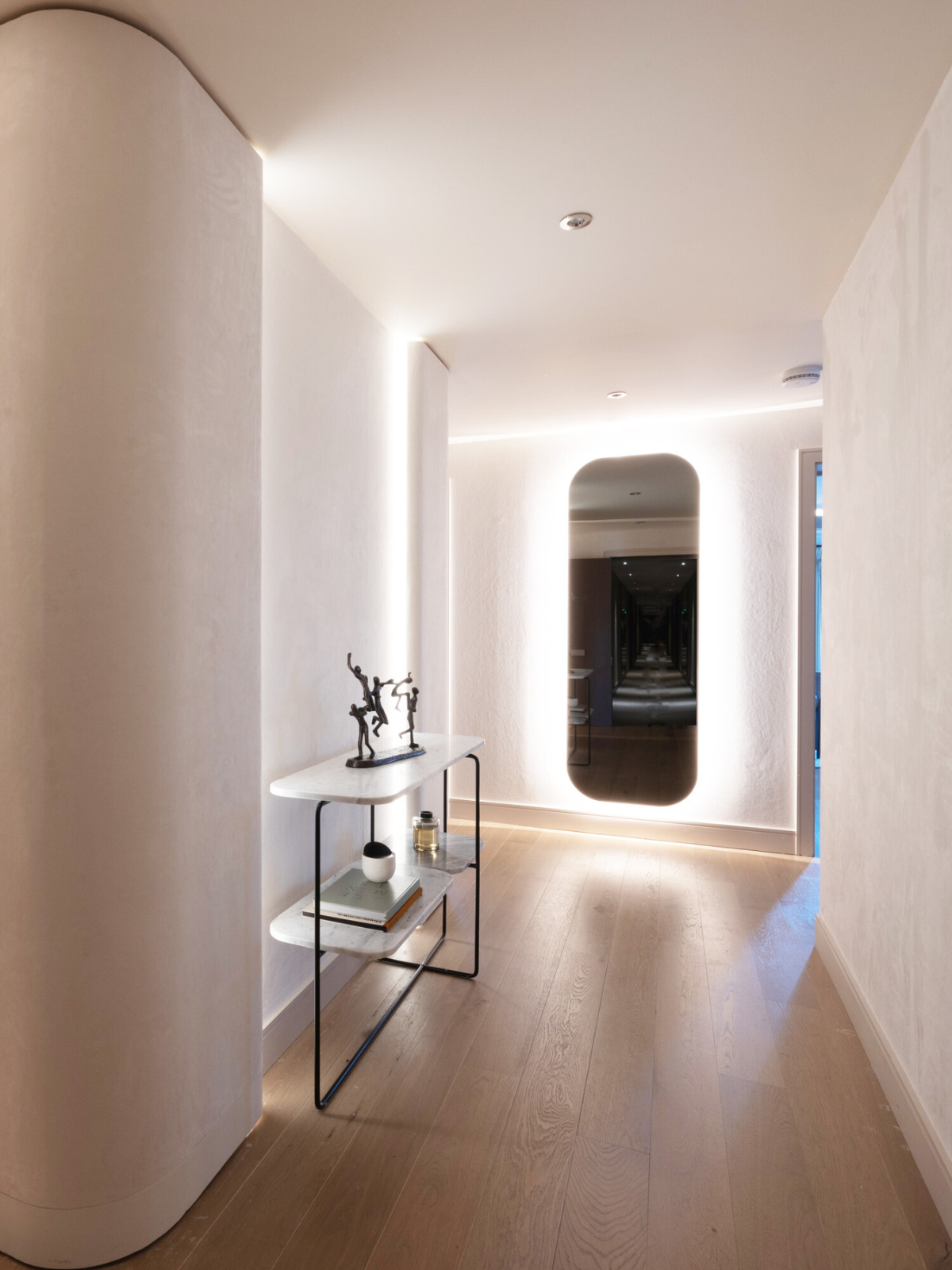 hallway with backlit mirror as focal point
