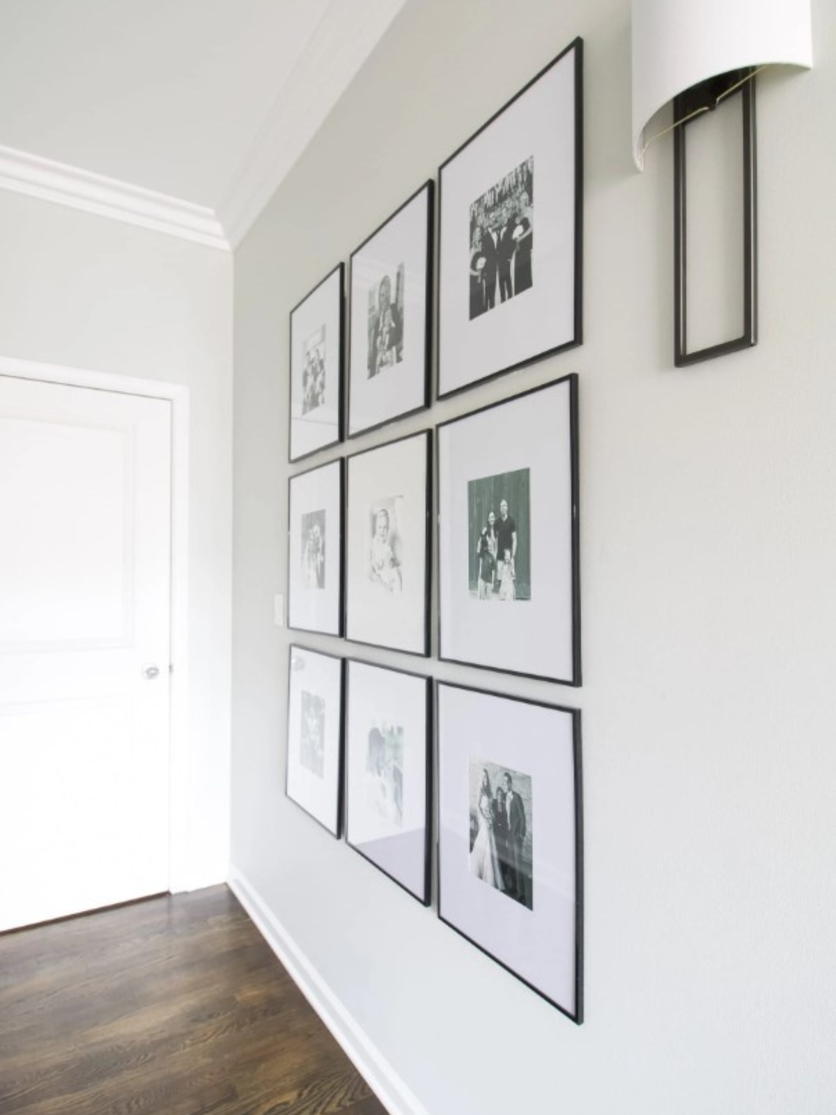 gallery wall with family photos in black frame on white painted wall