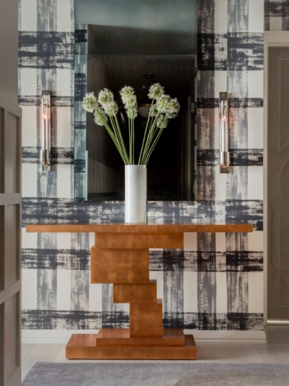 hallway with accent console table, wallcovering and tall vase with flowers