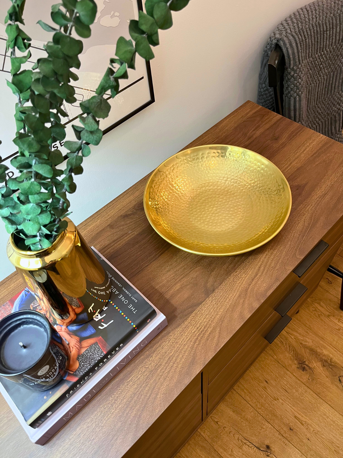 hallway console table with drawers in walnut laminate finish complete with decors such as steel golden tray, golden vase and books