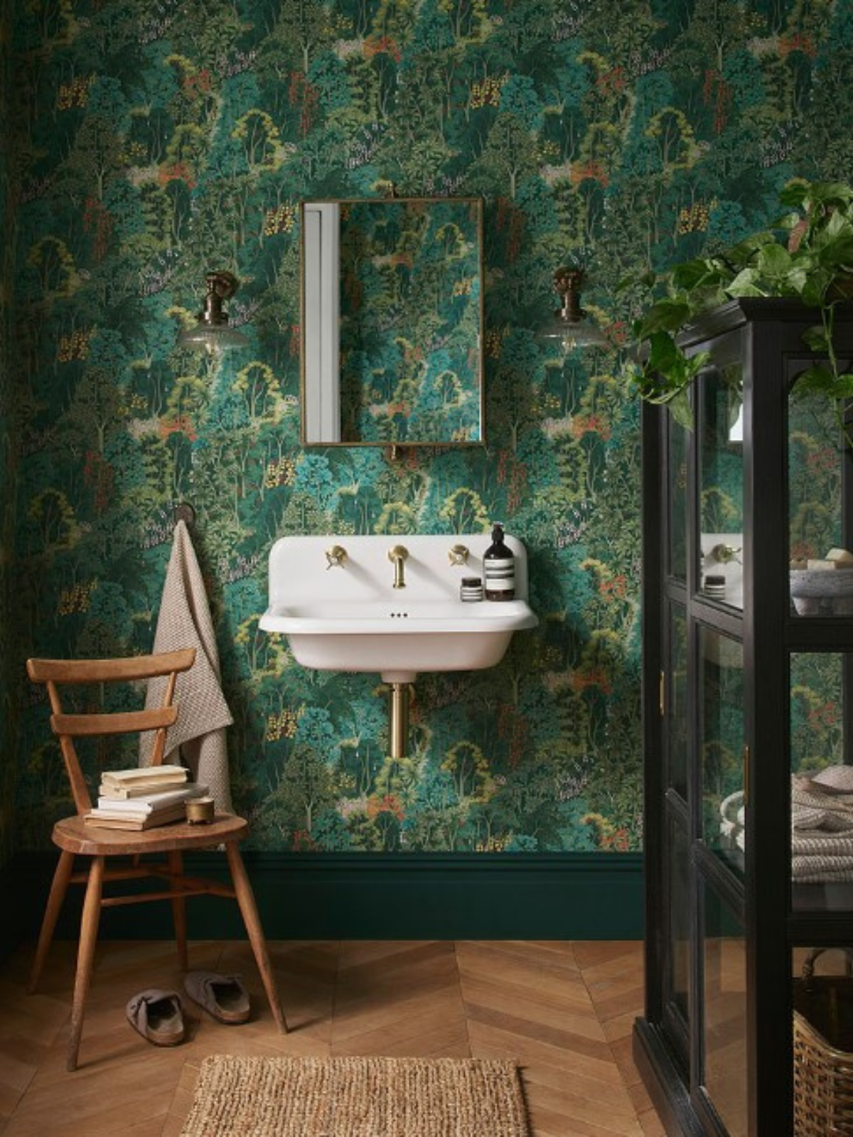 powder room with bold wallpaper, a chair, vanity sink, mirror and display cabinet
