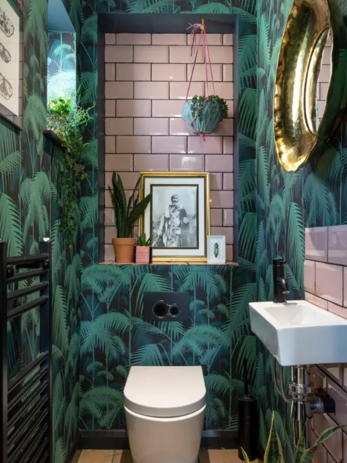 powder room with tropical inspired wallcovering, plants as decor and pink accent tiles