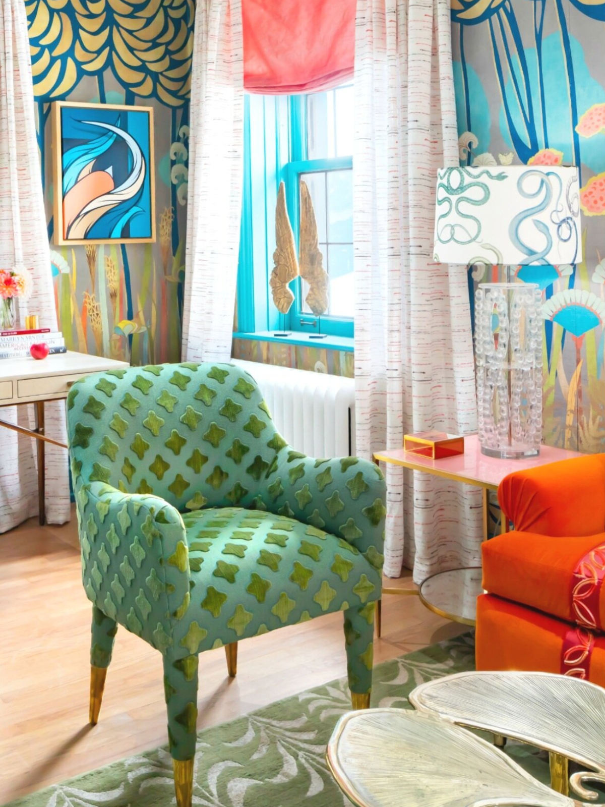 a vibrant living room with green accent chair, print wallcovering and colorful area rug and sofa