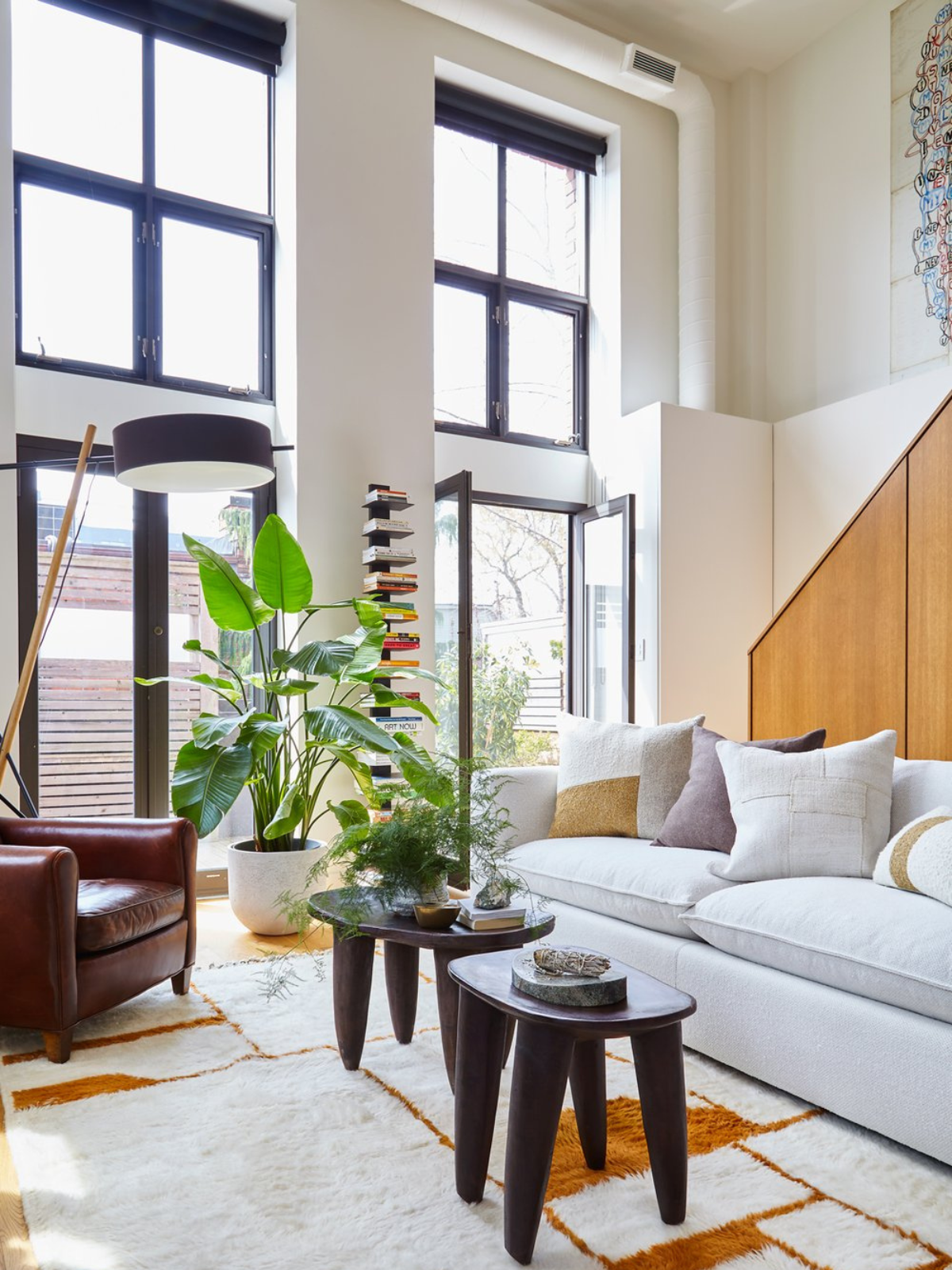 living room showing bog windows, white walls, grey sofa and wooden coffee table