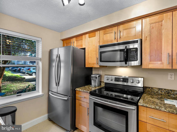 Classic kitchen with wood cabinets window with white wood frame