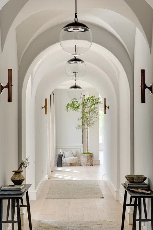hallway with white painted walls, wooden floor and glass globe pendant lights