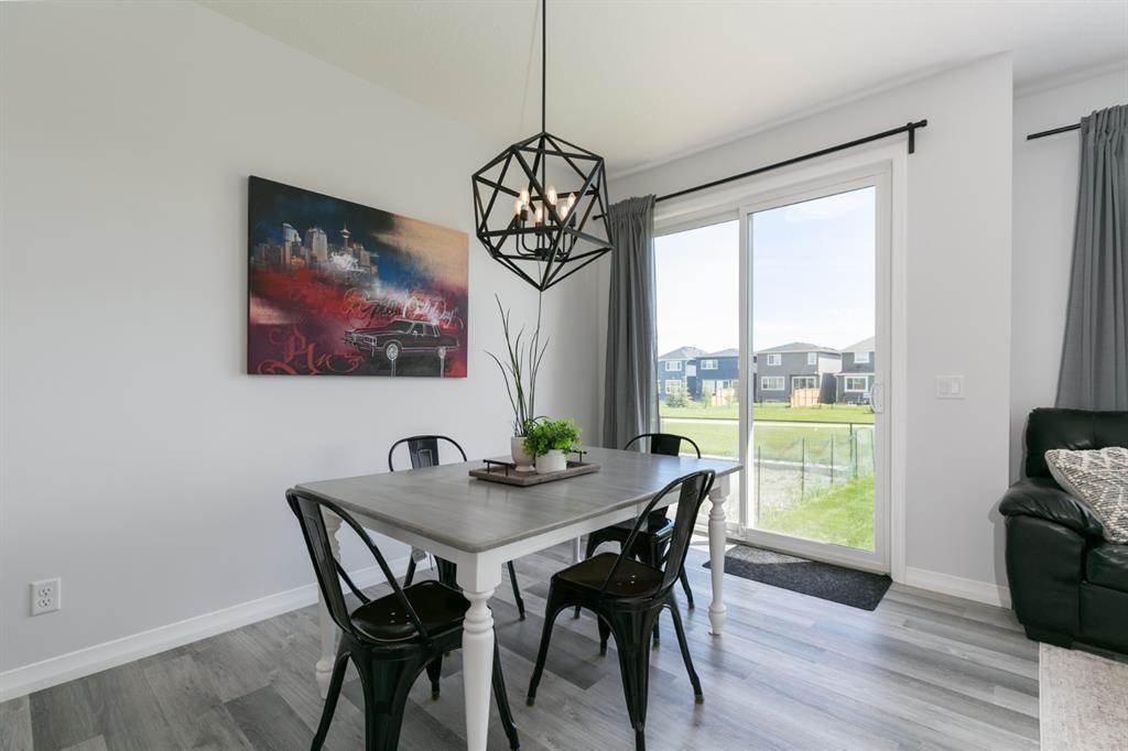 Calgary home listing dining area interior modern and farmhouse style with pendant light dining table chairs and white wall luxury vinyl planks flooring