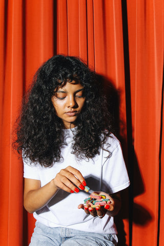 Woman in White Shirt Holding CBD gummies