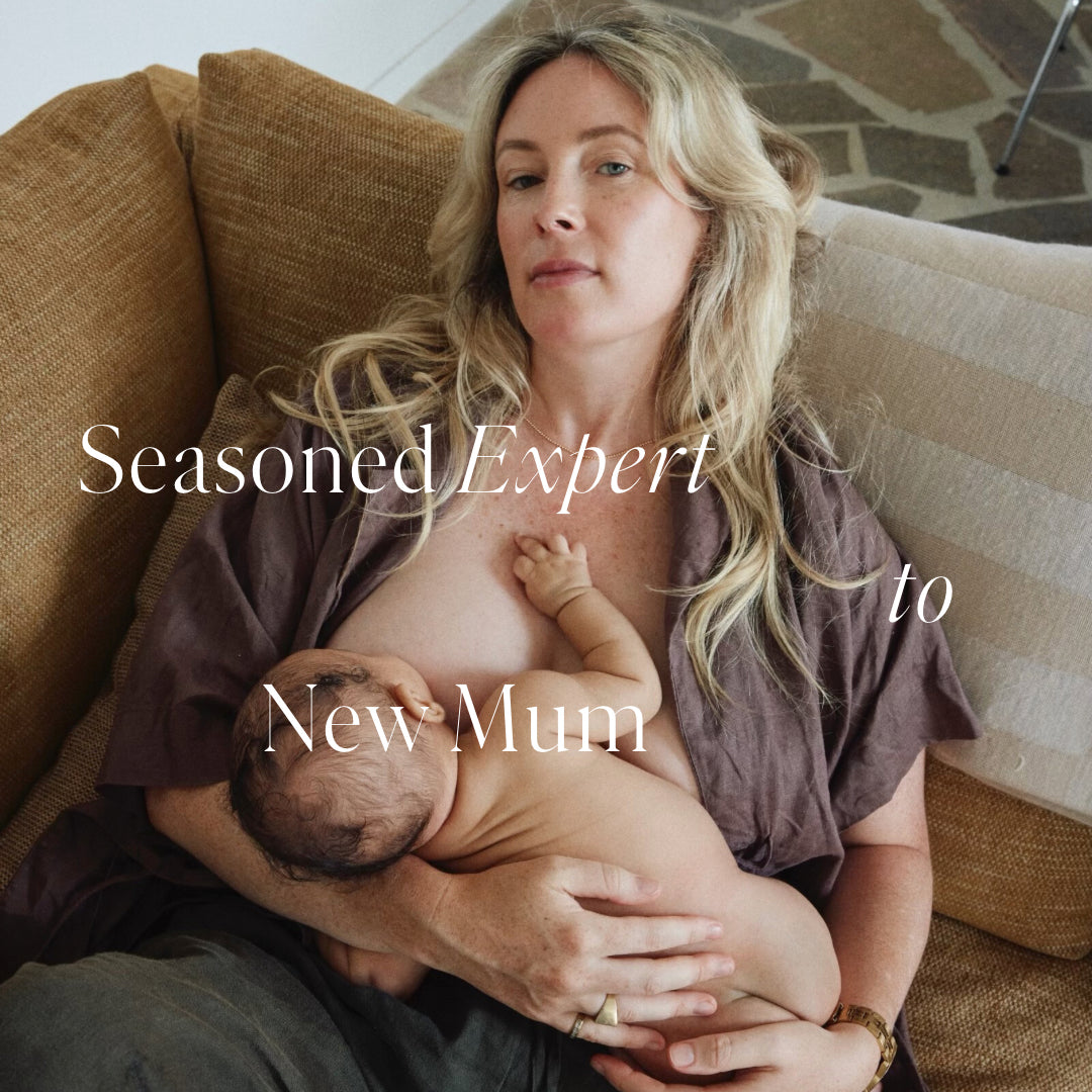 Joelleen Winduss Paye seated breastfeeding newborn baby on neutral couch