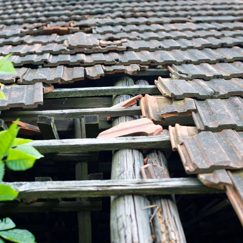 A high quality photo showing the effects of constant rainfall causing a large, leaky hole in a home's roof