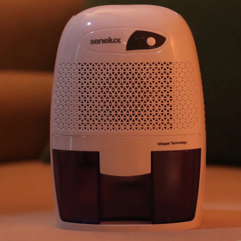 A Senelux XROW Mini Dehumidifier set against a cosy, orangish background