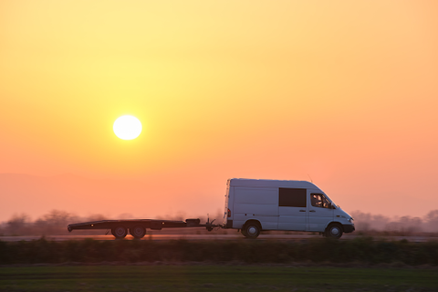 shipping van driving in sunset