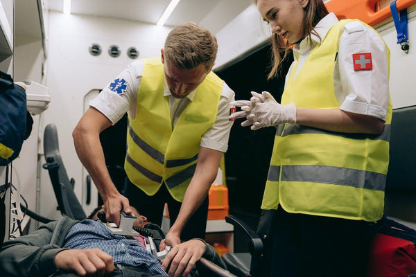 first responder using defibrillator on patient
