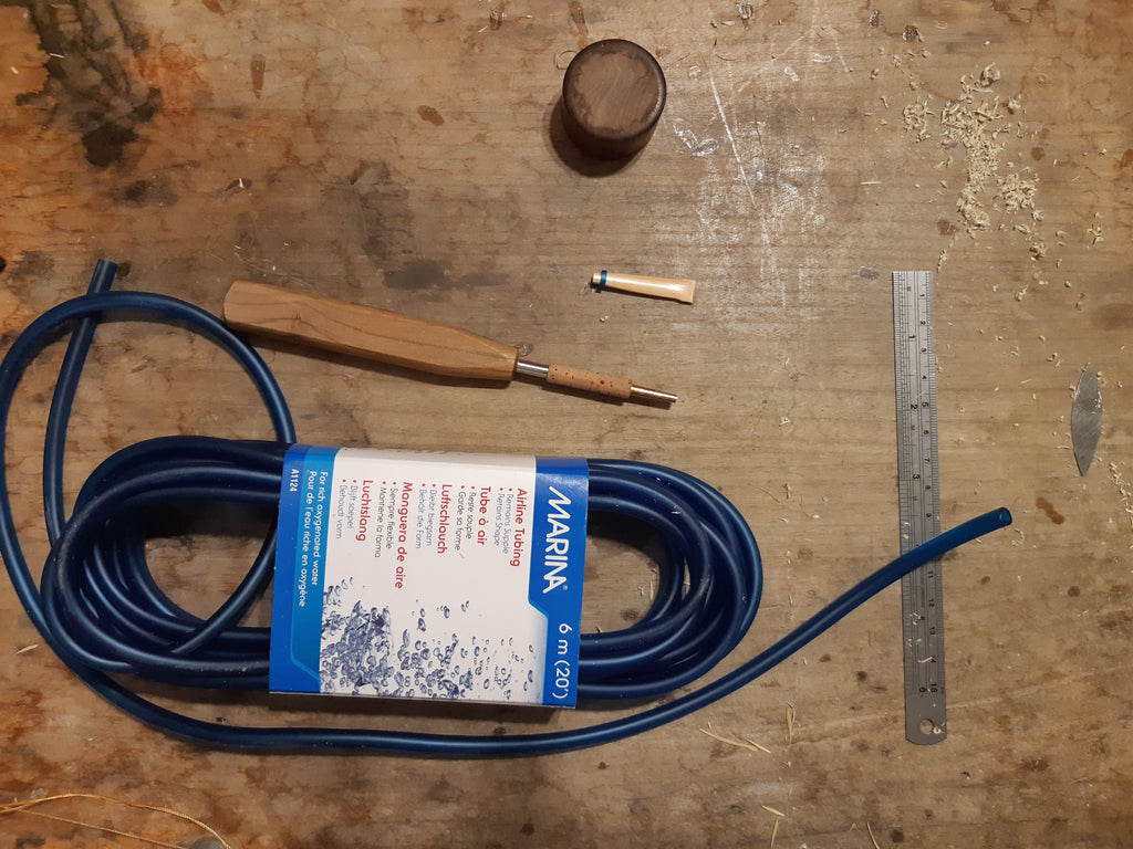 a piece of aquarium tubing holding the cane for tying a reed