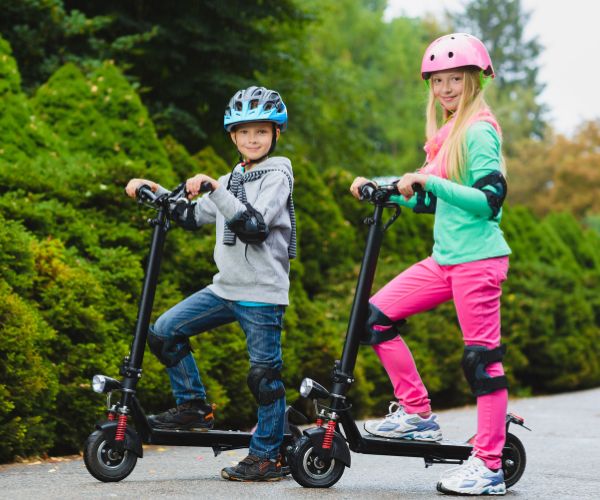 Happy kids standing on electric scooter outdoor | ENVO