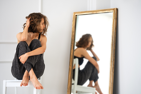 Notes for entrepreneur reflection as woman looks in the mirror