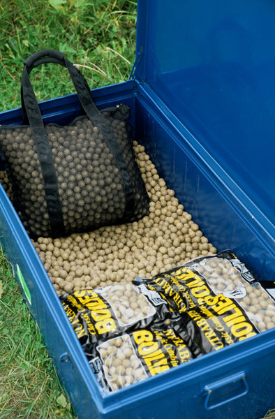 Photo of blue plastic bait box, filled with boilies, and a bag of boilies and two further bags