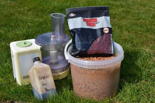 Blender, soy sauce bottle, red boilies and bucket of fishing crumb.