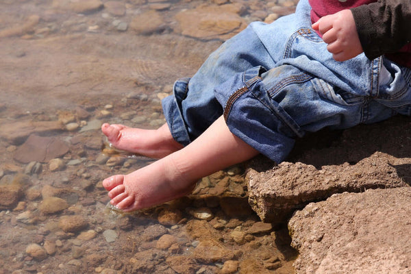 Baby with feet in water.