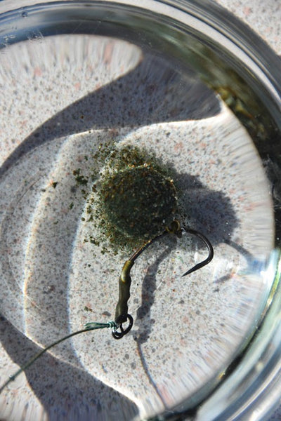Green fishing bait dissolving in water.