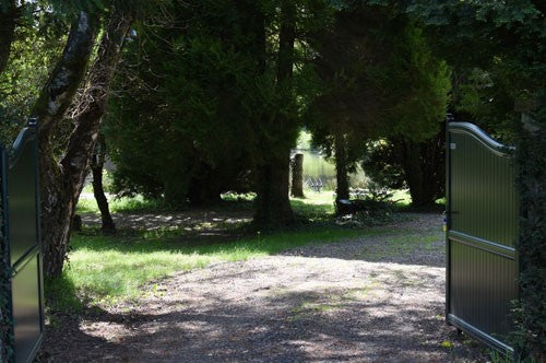 Open gate leading to a French lake.