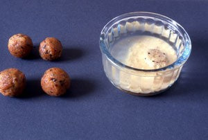 Four brown boiled paste balls next to a small glass dish.