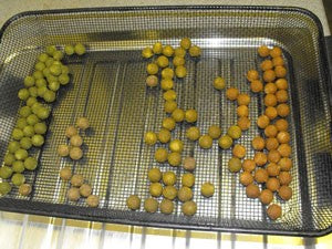 Sphere coloured boilies, cooked on a silver baking tray.