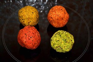 Four circular boilies - yellow, orange, red and green.