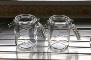 Two glass jam jars with open lids.