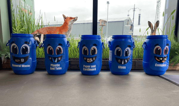 Recycling bins with colourful faces.