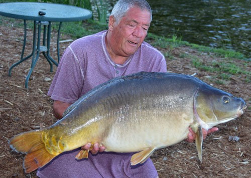 Ken holding a large carp he caught using his homemade bait.