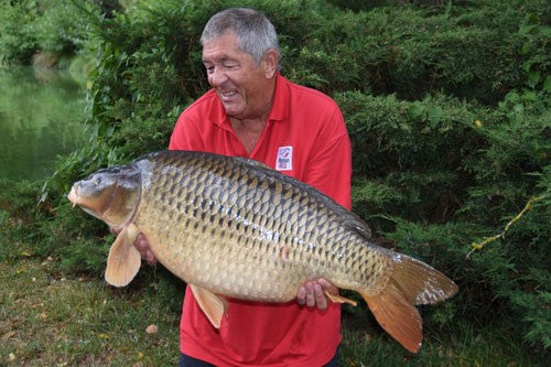 Ken smiling whilst holding a massive carp.