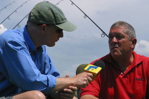 A man holding a microphone in front of Ken Townley.